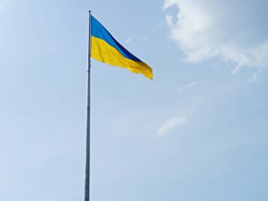 Mavi gökyüzünde dalgalanan Ukrayna ulusal bayrağı.