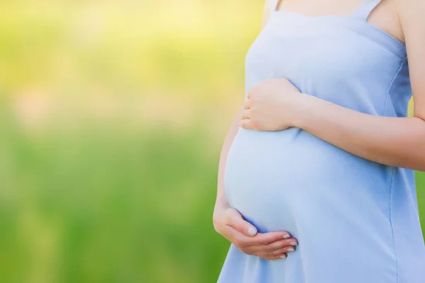自然を背景に青いドレスを着た妊婦さんがクローズアップ 母親の概念 コピースペースと子供の概念への愛 — ストック写真