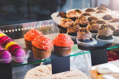 Kafede şekerli bir vitrin. Kekler ve renkli kurabiyeler pasta sergisinde. Tatlı tatlılar