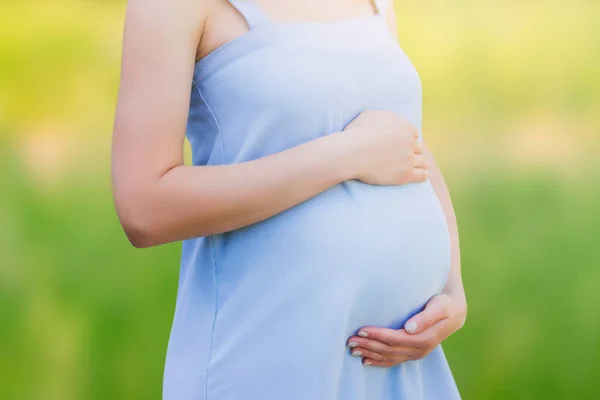 自然を背景に青いドレスを着た妊婦さんがクローズアップ 母親の概念 コピースペースと子供の概念への愛 — ストック写真