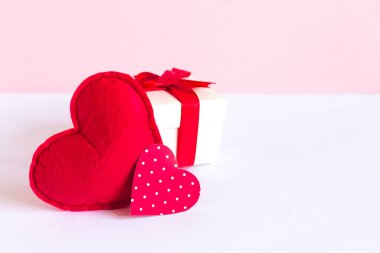 İki kırmızı kalp, pembe arka planda hediye kutusu, tebrik kartı, metin için fotokopi alanı olan sevgililer günü konsepti.