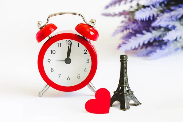 Romantic trip to Paris concept. Honeymoon, time to fall in love. Invitation to a romantic trip, a love note. Eiffel tower with red alarm clock