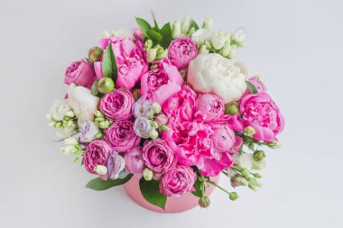 Şapka kutusunda çiçek aranjmanı. Şakayık buketi, coşku, pembe bir kutuda gül, beyaz bir arka planda vaha.