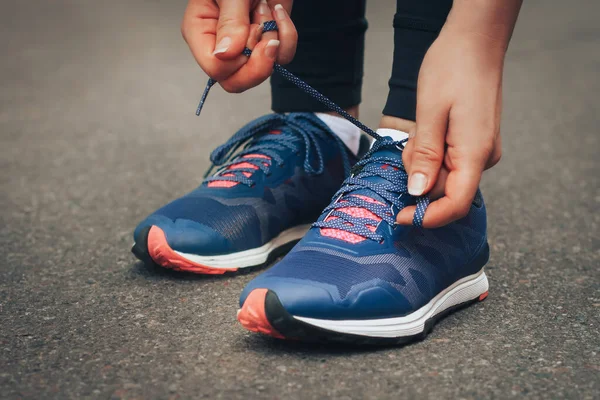 Akşam koşusu. Kırsal bir yolda mavi spor ayakkabılarla günbatımında koşan genç bir bayan. Koşmadan önce ayakkabı bağcıklarını bağlayan kız