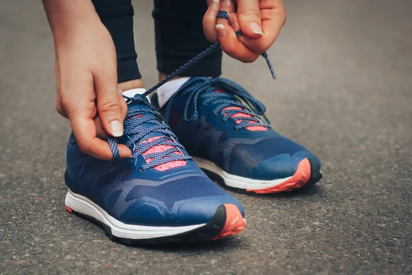 Akşam koşusu. Kırsal bir yolda mavi spor ayakkabılarla günbatımında koşan genç bir bayan. Koşmadan önce ayakkabı bağcıklarını bağlayan kız