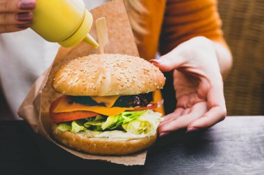 Siyah ahşap masada patates kızartmalı taze lezzetli hamburger.