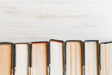 Bir yığın eski kitap, beyaz ahşap arka planda ders kitapları. Hafif arkaplanda satır aralığı