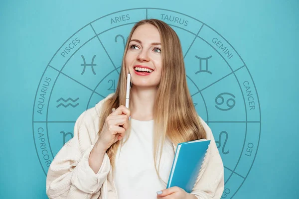 Ung Kvinna Som Håller Penna Och Anteckningsblock Händerna Med Zodiak — Stockfoto