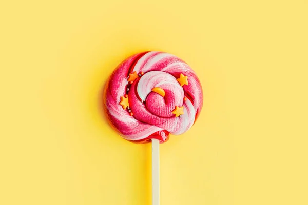 Kleurrijke Roze Lolly Geïsoleerd Gele Papieren Achtergrond Plat Gelegd Begrepen — Stockfoto