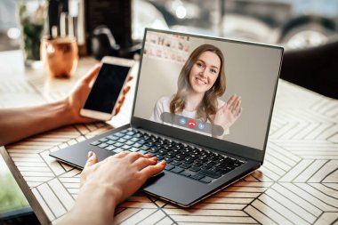 Kız beyaz dizüstü bilgisayarlı bir kafede oturuyor ve daktilo ediyor. Model, arka plan