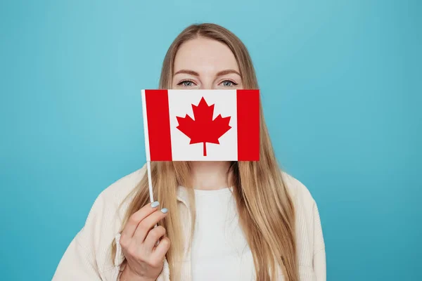 加拿大日 加拿大假日 邦联周年纪念日 复制空间 用加拿大小国旗盖住她的脸 并在蓝色背景下拍摄她的近照 — 图库照片