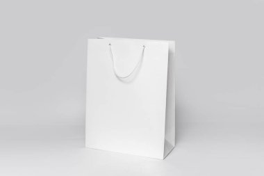 Beyaz kağıt arka planda izole edilmiş beyaz alışveriş çantasının bir kopyası. yan görünüm