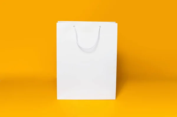 Образец Белого Мешка Покупок Фоне Оранжевой Бумаги Прямой Вид — стоковое фото