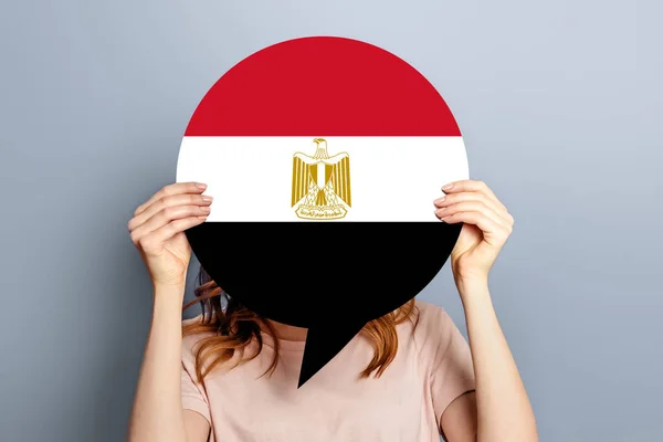 Egypt news concept. Female hands holding a round information piece of paper dialog with Egypt Flag isolated over grey studio background. election concept