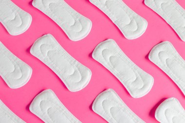 Pembe arka planda kadın adet pedleri, kadın sağlığı, adet döngüsü konsepti