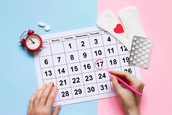 Regl takvimi, çalar saat, hormonal doğum kontrol hapları. Kadınların adet döngüsü konsepti. Regl gecikmesi konsepti
