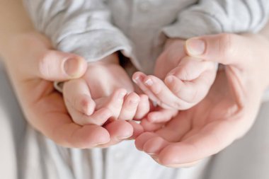 Annem yeni doğmuş bir bebeğin elini tutuyor. Çocukla duygusal bir bağ. Ukraynalı yeni doğmuş. Annesinin kollarında bebek