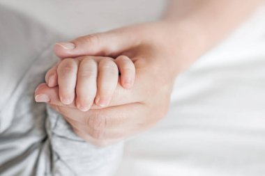 Annenin elinde uyuyan bir bebeğin eli. Annemden yeni doğmuş bebek. Annelik bakımı ve bebek bakımı. Boşluğu kopyala