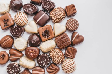 Beyaz arka planda izole edilmiş koyu, beyaz ve sütlü çikolata çeşitleri. Yer mantarı, dekorasyon tasarımlı şeker. Çeşitli şeker dolguları. Yukarıdan görüntüle