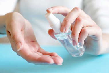 Bir şişe antiseptik sprey tutan ve hijyen için antibakteriyel alkol kullanan kadın eller koronovirüs bakterileri, pandemik, karantina, el hijyenine karşı ellerini yıkıyor.