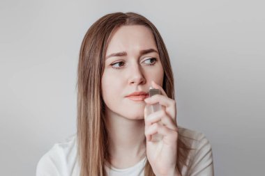 Koku kaybı konsepti. Beyaz arka planda izole edilmiş beyaz kadın parfüm kokluyor.