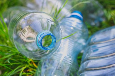 Çimlerdeki plastik şişeler, çevre kirliliği, çevresel sorunlar, plastik ekolojik sistemin tahrip edilmesi. Çöp, çöp.