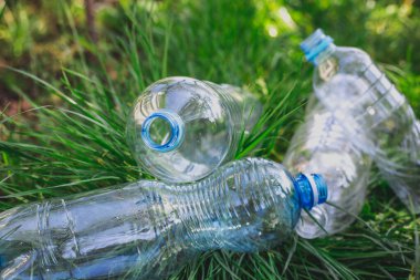 Çimlerdeki plastik şişeler, çevre kirliliği, çevresel sorunlar, plastik ekolojik sistemin tahrip edilmesi. Çöp, çöp.