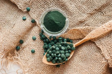 Tabletlerde yeşil yosun spirulinası ve çuval bezinde pudra. Üst görünüm