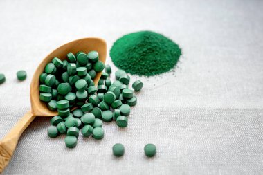 Tabletlerde yeşil yosun spirulinası ve çuval bezinde pudra. Sebze proteini. Uzayı kopyala Sağlıklı sebze proteini. Süper yemek.