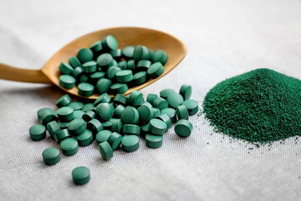 Haplar ve deniz yosunu sarmaşığı tozu, tahta kaşıkta klorella. Bitki proteinli vejetaryen süper yiyecekler. Deniz vitaminleri, mineraller