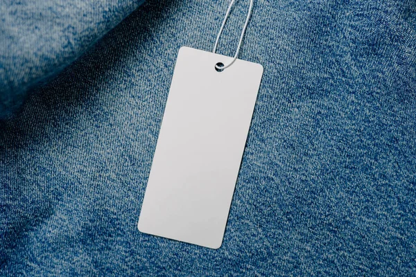 White empty clothing tag, label blank mockup for design on a jeans