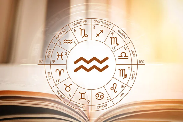 Zodiac çemberi, üzerinde akvaryum işareti olan açık bir kitabın arka planına karşı. Zodiac 'ın işaretleri için astronomik tahminler. İşaret akvaryumunun özellikleri. Astroloji, ezoterizm, gizli bilim
