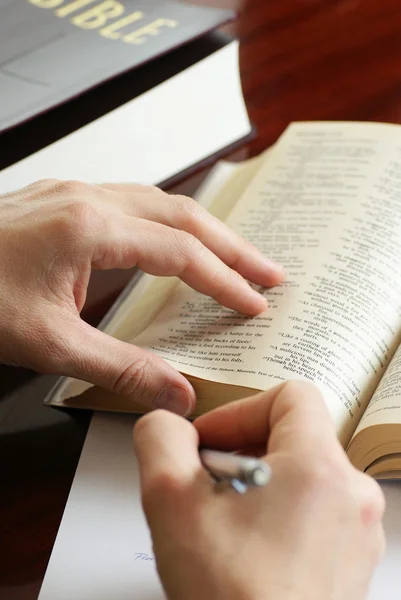 Detail rukou s perem a otevřené bible — Stock fotografie