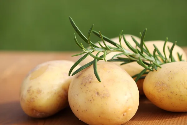 Alecrim fresco e batatas cruas — Fotografia de Stock