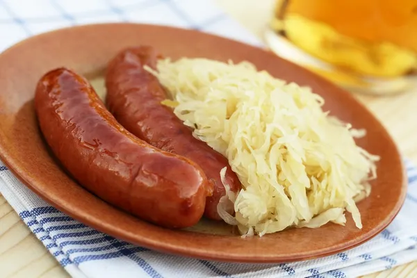 Plate with sausages and pickled cabbage — Stock Photo, Image