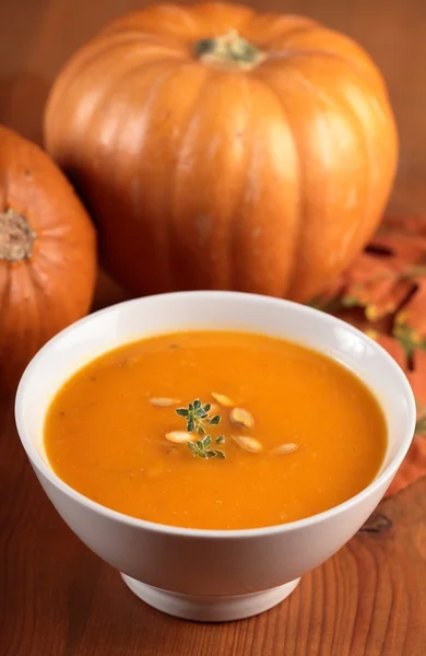 Bowl with pumpkin soup and pumpkins. — Stock Photo, Image