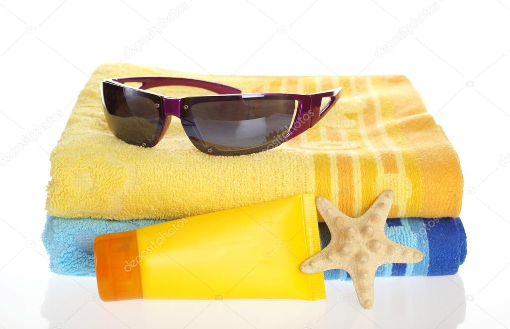 Sunglasses, sun lotion and towel