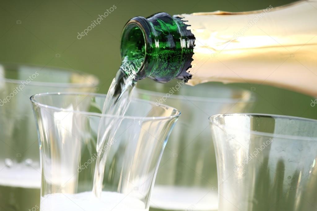 Close-up of bottle and pouring sparkling wine.
