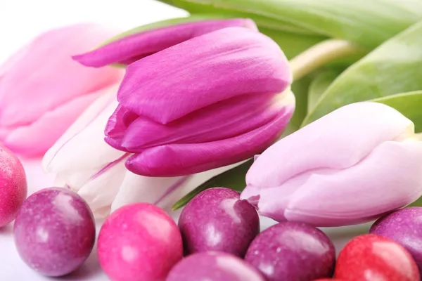Close-up of chocolate eggs and tulips. — Stock Photo, Image