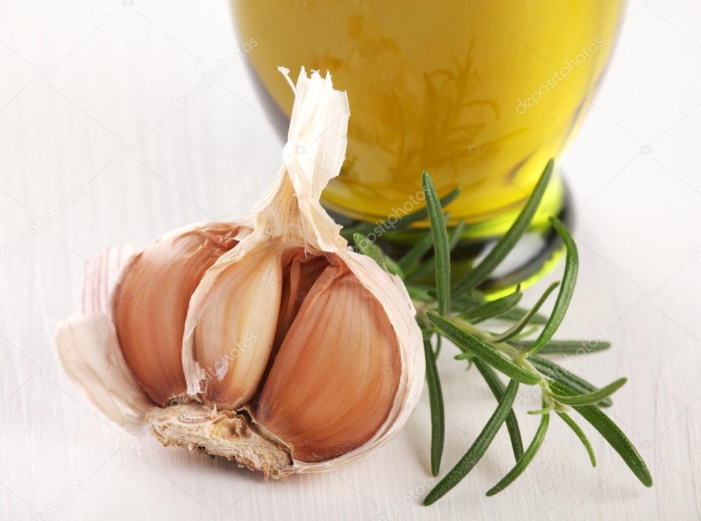 Close-up of garlic, rosemary and olive oil.
