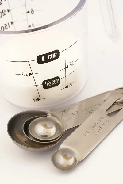 Measuring cup with sugar and measuring spoons