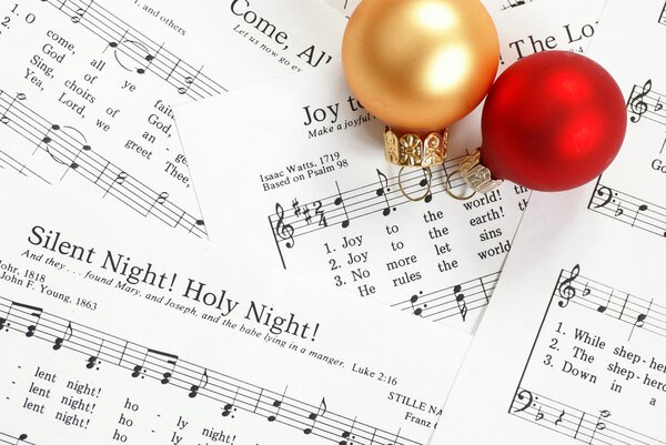 Музыкальные ноты с рождественскими песнями и рождественскими украшениями
