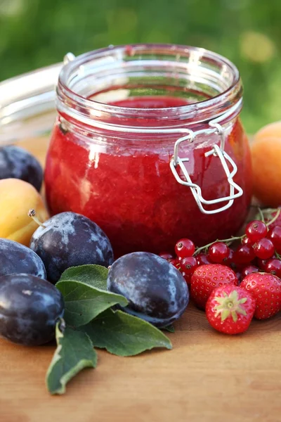 Vaso con marmellata fresca e frutta in giardino — Foto Stock