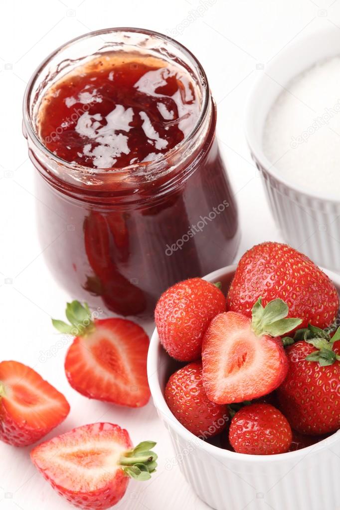 : Bowls with strawberry jam, fresh strawberries and sugar.