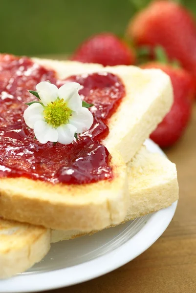 Primer plano de la tostada con mermelada de fresa en el plato — Foto de Stock