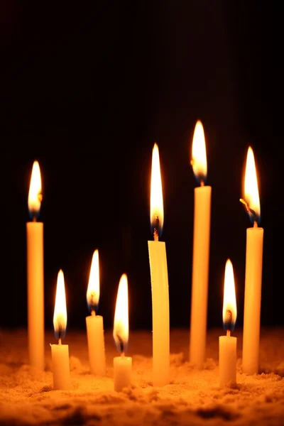 Candles in sand and black background — Stock Photo, Image