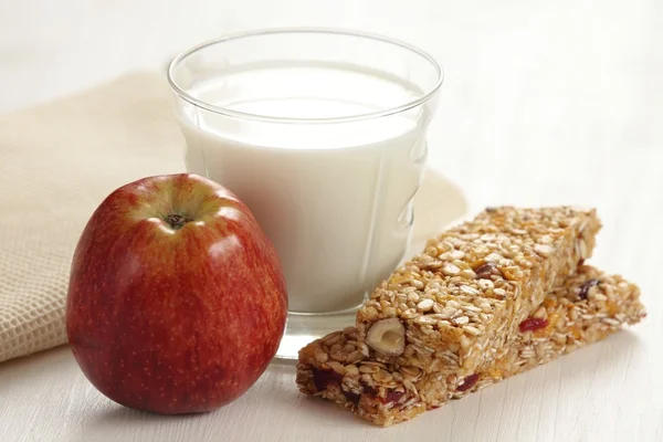 Müsliriegel, Apfel und Glas Milch. — Stockfoto