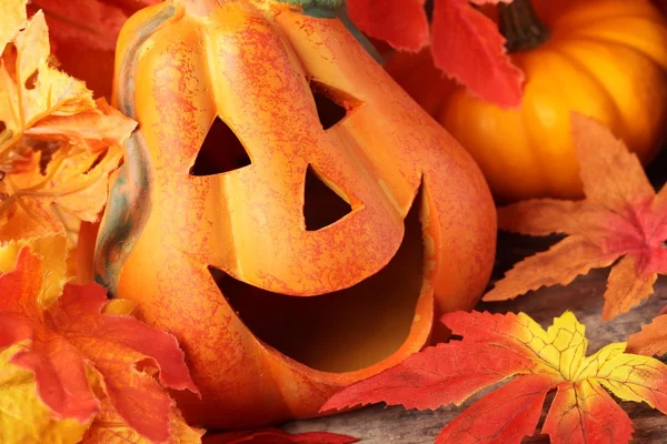Usměvavá dýňová hlava a dekorativní podzimní listí — Stock fotografie