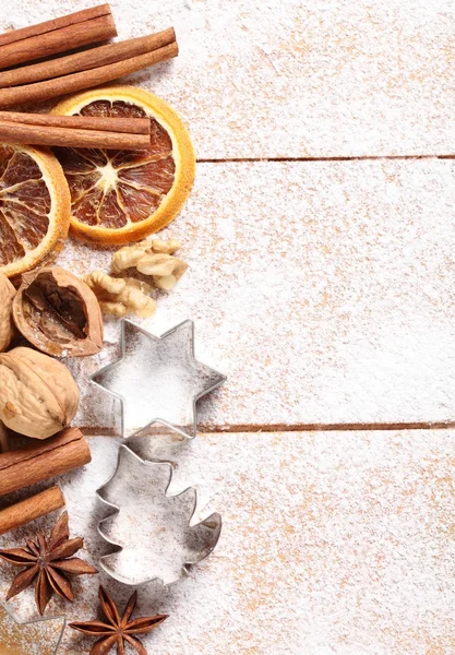 Nueces, especias y cortadores de galletas sobre fondo de azúcar —  Fotos de Stock