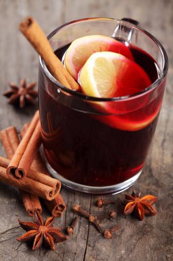 Ahşap arka planda sıcak şarap ve baharatlar.